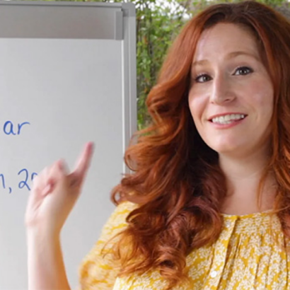 Woman pointing to a white board.