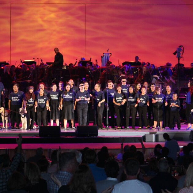 Braille youth choir on stage with Cyndi Lauper.