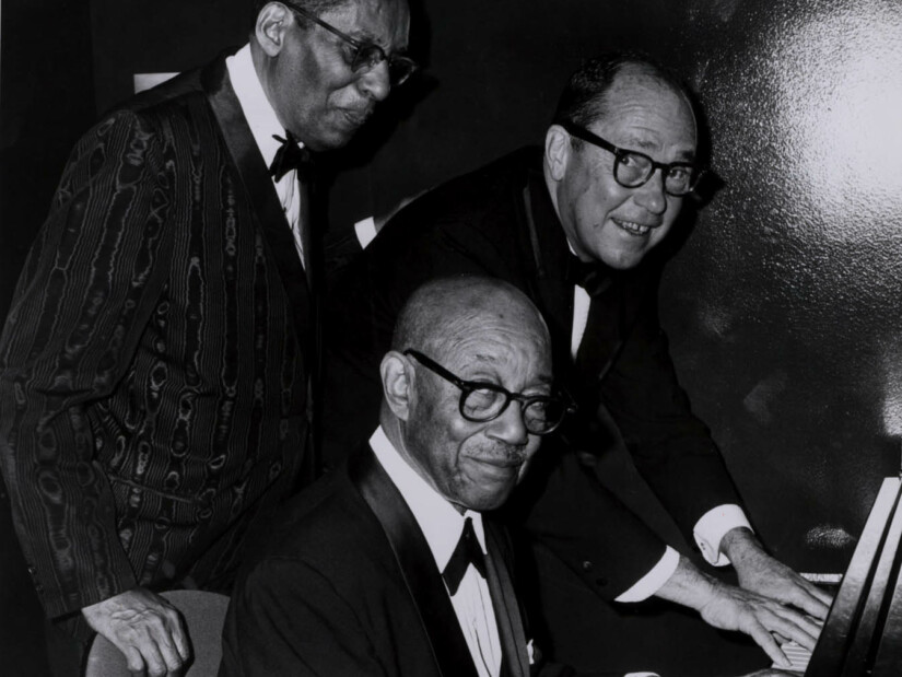 Johnny Mercer with fellow musicians playing the piano.