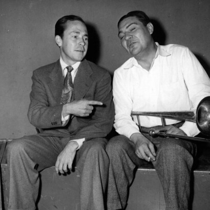 Johnny Mercer sitting with a man with a trombone.